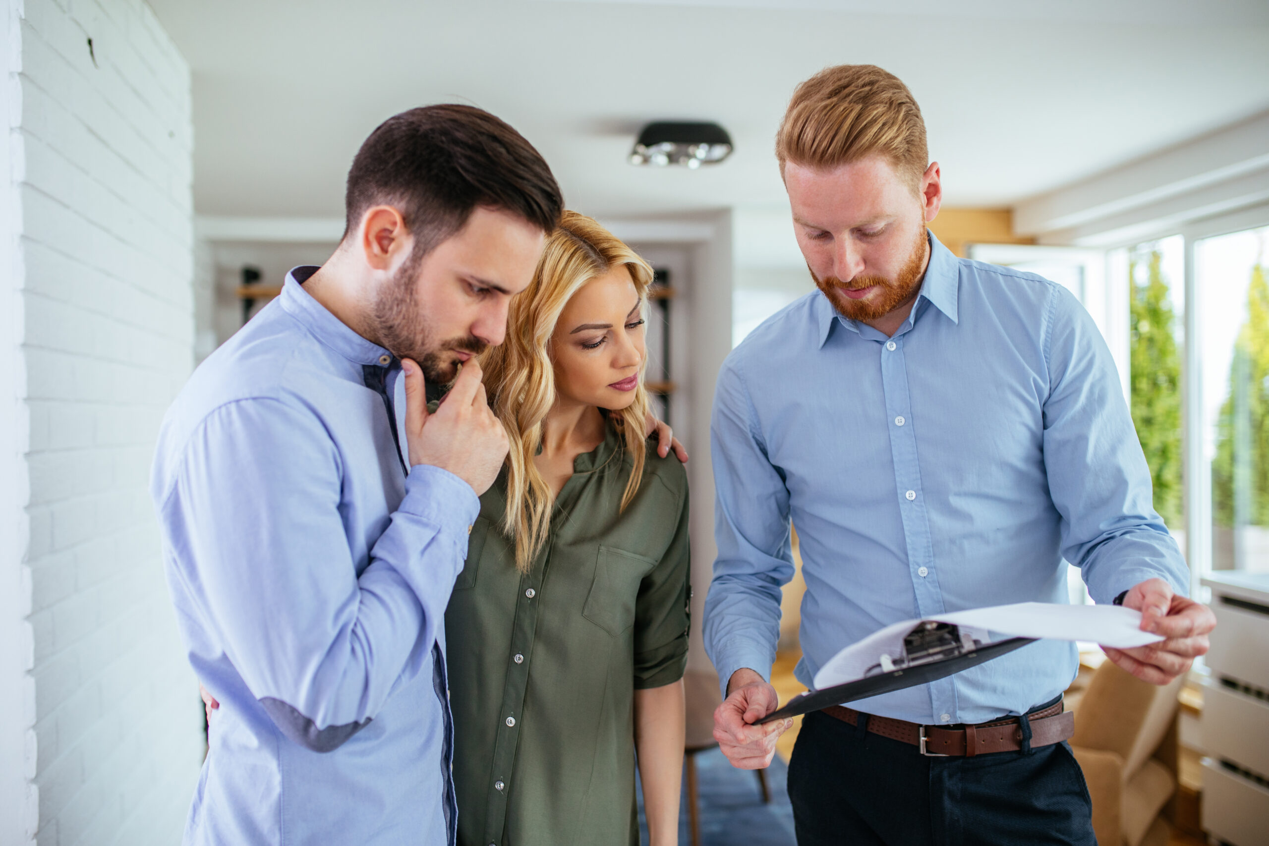 Male consulant showing property contract to the couple.